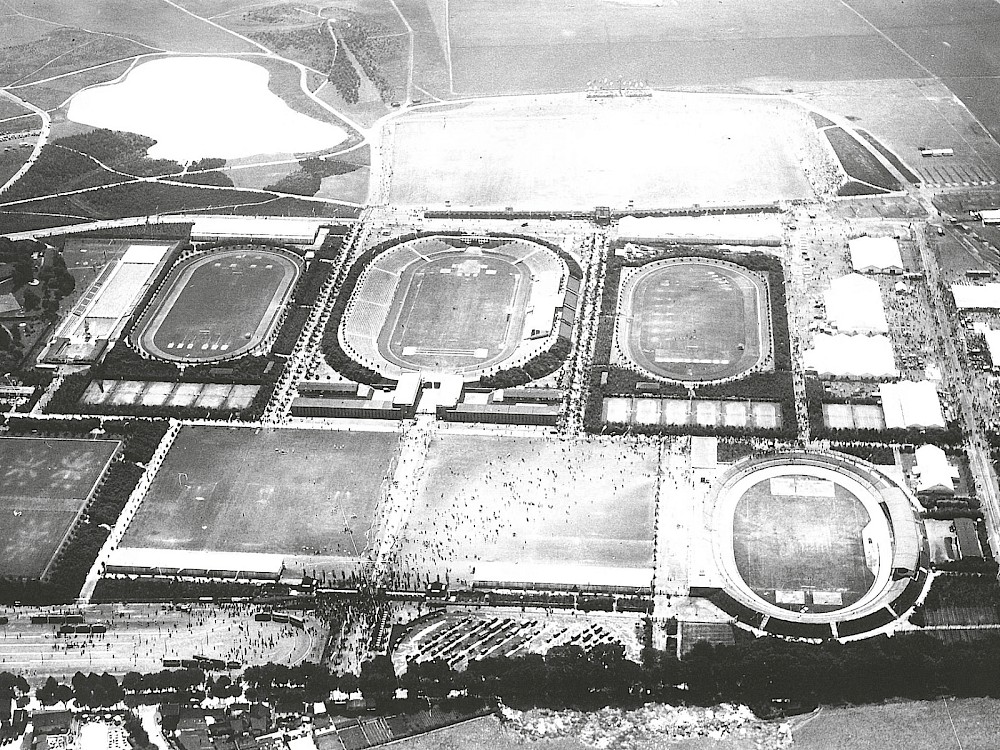 Der Sportpark Müngersdorf mit Schwimmbad (links) und Stadion (Mitte) kurz nach seiner Eröffnung im Jahr 1926. Im Hintergrund ist gut der Adenauer Weiher zu erkennen, der Stadtwald in dieser Zeit war noch nicht sehr hoch gewachsen. Foto: Carl und Liselott Diem Archiv